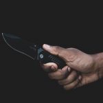 hand holding knife with a black background